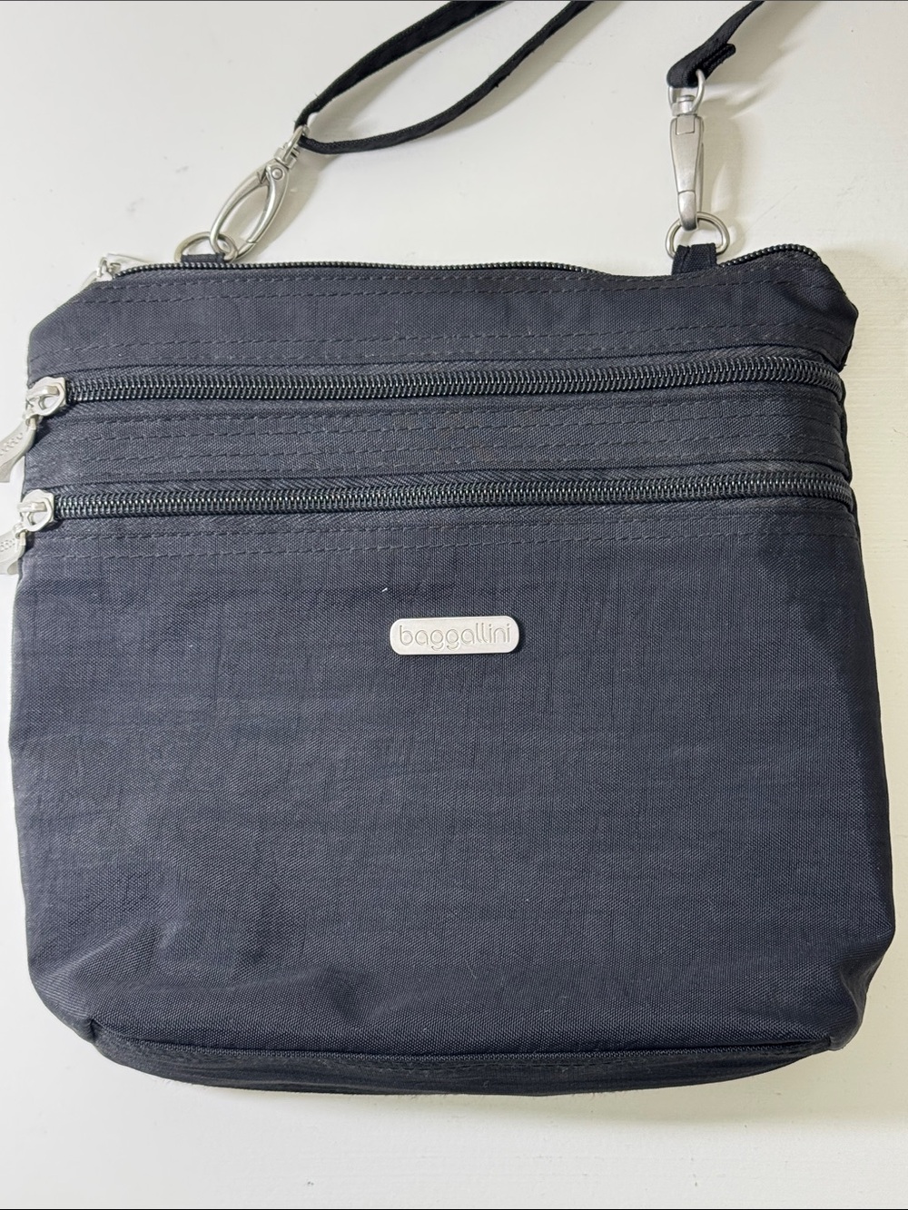 Baggalini black nylon crossbody bag with matching integrated mini bag/wallet.